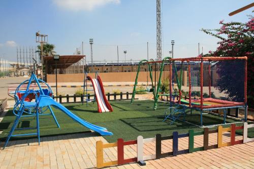 a playground with several slides and swings at Grand Plaza Sheikh Zayed in Kafr Abū ʼumaydah