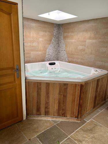 a jacuzzi tub in the corner of a room at Maison coup de cœur in Fauverney