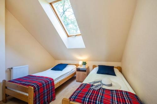 2 łóżka w sypialni na poddaszu ze świetlikiem w obiekcie Pokoje Gościnne POD KNOTEM w mieście Karwieńskie Błoto Drugie