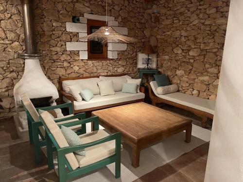 uma sala de estar com um sofá, uma mesa e cadeiras em Casa Goro Formentera em Es Migjorn