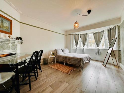 倫敦的住宿－Rest Boutique Golders Green，卧室配有一张床和一张桌子及椅子