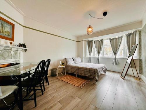 a bedroom with a bed and a table and chairs at Rest Boutique Golders Green in London