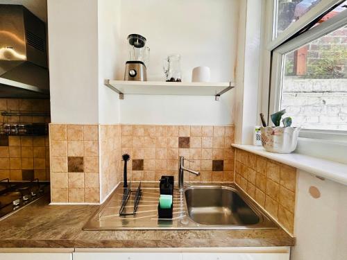 a kitchen with a sink and a window at Rest Boutique Golders Green in London