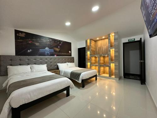 a bedroom with two beds and a football game on the wall at Hotel Soy Caribe in Bogotá