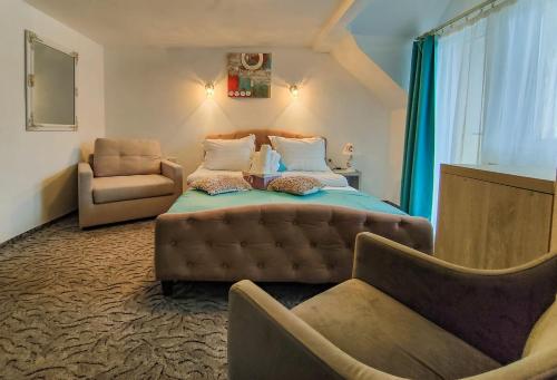1 dormitorio con 1 cama, 1 sofá y 1 silla en Anelisse Inn, en Moieciu de Sus