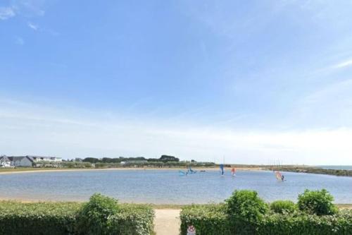 Une grande masse d'eau avec des gens qui y nagent dans l'établissement Appartement Etel, à Étel