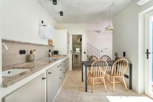 タヴィラにあるCasas da Formosa - Casa das Olariasのキッチン(黒いテーブル、椅子付)