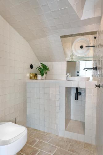 a white bathroom with a toilet and a sink at Casas da Formosa - Casa das Olarias in Tavira