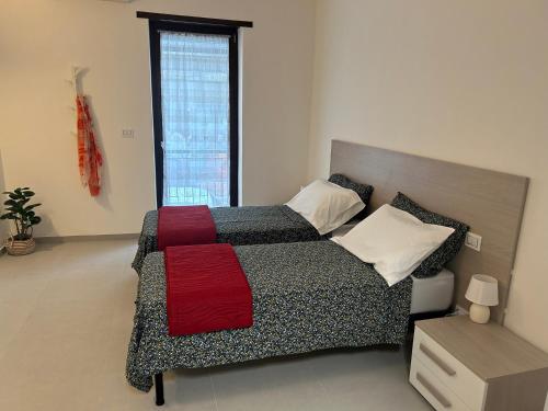 a bedroom with a large bed with a red blanket at Lettera 22 Apartment in Brindisi