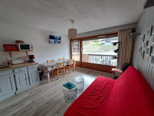 un salon avec un canapé rouge et une table dans l'établissement appartement T2 coin montagne, à Vars