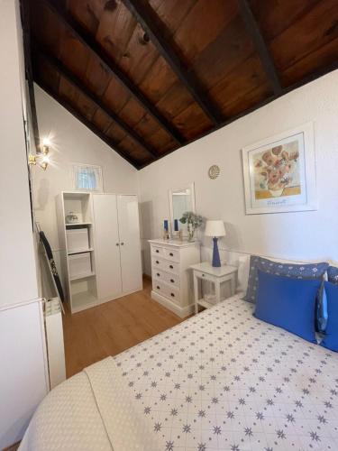 1 dormitorio con cama y techo de madera en La casita de Mazo en Mazo