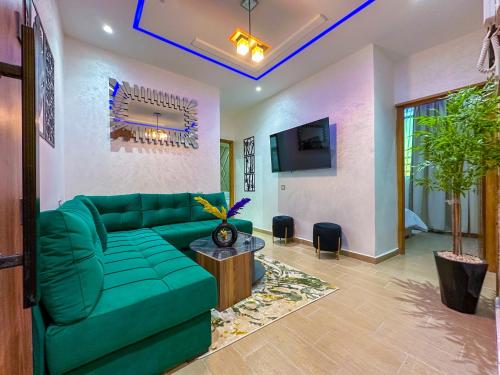 a living room with a green couch and a tv at VELUXA - LUXURY HOLIDAY HOMES - Centric flat in Tangier
