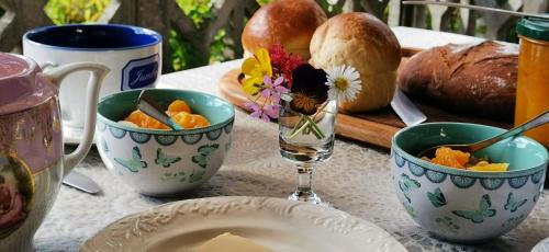 une table avec deux bols de fruits et un verre d'eau dans l'établissement la maison de tante Jeanne, à Marcols-les-Eaux