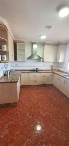 an empty kitchen with a red floor in a room at Villa Maruna in Grao de Castellón
