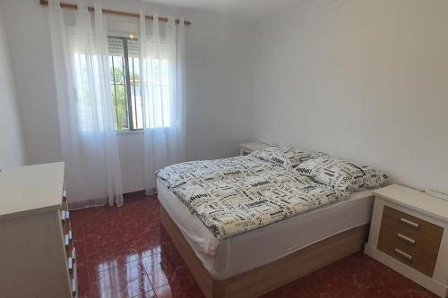 a bedroom with a bed and a desk and a window at Villa Maruna in Grao de Castellón