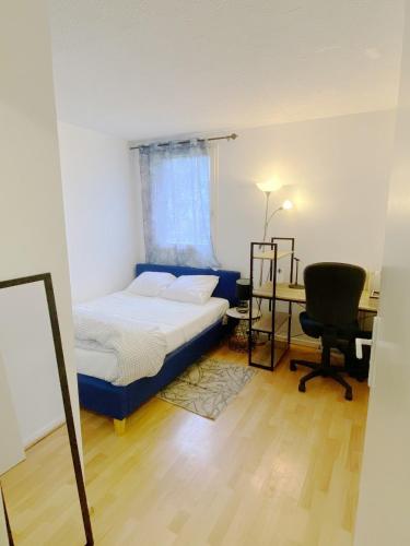 a bedroom with a bed and a desk and a chair at Noxio voyages in Evry-Courcouronnes