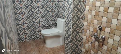 y baño con aseo en una pared de azulejos. en Hotel Jubilant Stays, en Bangalore