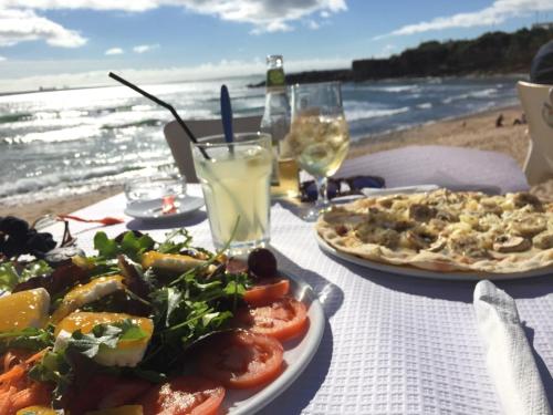 a table with two plates of food on the beach at 5minutos do jardim até ao mar in Parede