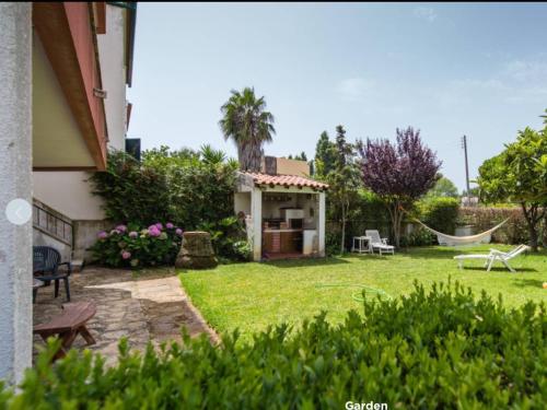 a backyard with a hammock and a house at 5minutos do jardim até ao mar in Parede