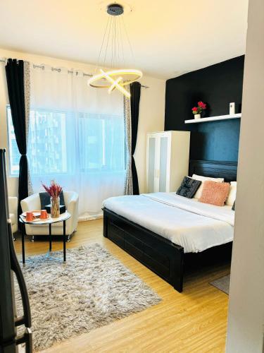 een slaapkamer met een groot bed en een kroonluchter bij DALA MASTER Bedroom En-suite in Sharjah