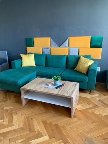 a living room with a green couch and a coffee table at Victory apartmán in Šamorín