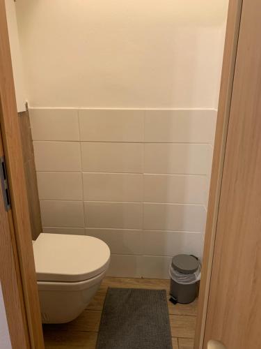 a small bathroom with a toilet and a trash can at Victory apartmán in Šamorín