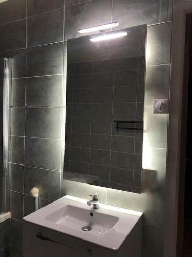 a bathroom with a sink and a mirror at Beau T2 rénové in Cluses