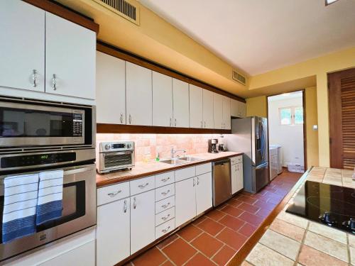 a kitchen with white cabinets and stainless steel appliances at Villa De Palma -Oceanfront community w generator in Sabana