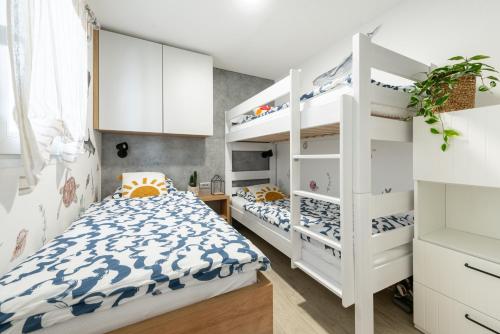 1 Schlafzimmer mit 2 Etagenbetten und 1 Bett in der Unterkunft Tiny home Rubi in Oaza Mira resort in Drage