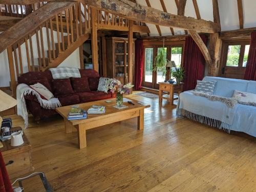 a living room with a couch and a coffee table at Cosy listed barn in peaceful country village in Grandborough