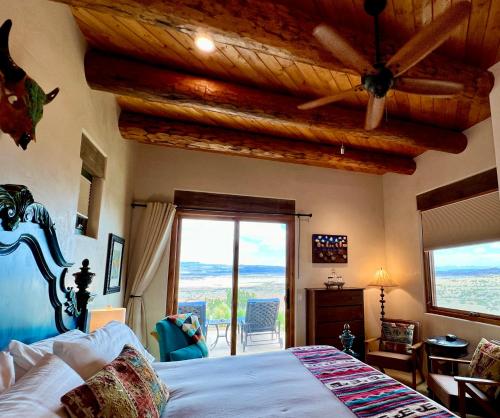 um quarto com uma cama e uma grande janela em The Grand Hacienda Estate with Breakfast em Abiquiu