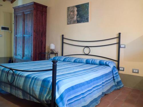 een slaapkamer met een bed met een blauw gestreept dekbed bij La Casa Nova in Sansepolcro