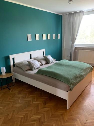1 dormitorio con 1 cama grande y pared azul en Victory apartmán en Šamorín