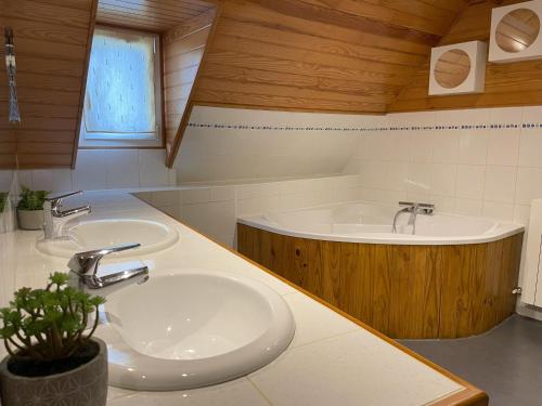 une salle de bain avec deux lavabos et une baignoire dans l'établissement L'épicerie, à Trébons