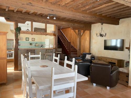 une cuisine et un salon avec une table et des chaises dans l'établissement L'épicerie, à Trébons