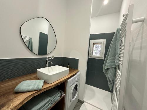 a bathroom with a sink and a washing machine at Maison de vacances in Gondrin