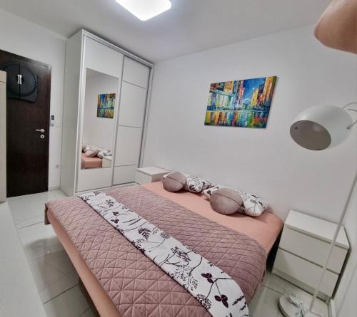 a bedroom with a bed with a pink comforter at Luxury apartment Antonija-old town in Cavtat