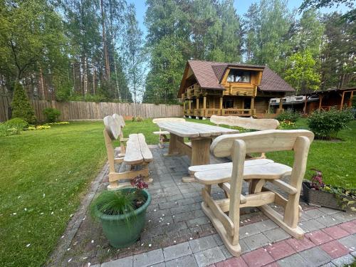 uma mesa de piquenique e banco em frente a uma casa em Guest house Saulainie krasti em Saulkrasti