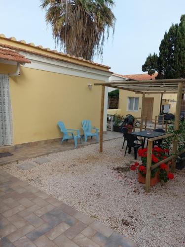 a patio with a table and two blue chairs at LA CONCHIGLIA località Caccia e Riserva in Santa Marinella