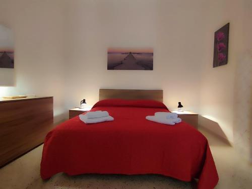 ein Schlafzimmer mit einem roten Bett mit zwei Handtüchern darauf in der Unterkunft Politeama my Suite in Palermo