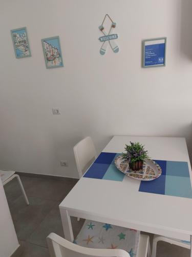 a white table and chairs with a potted plant on it at LA CONCHIGLIA località Caccia e Riserva in Santa Marinella