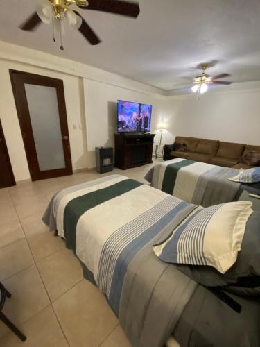a bedroom with two beds and a flat screen tv at Loft con baño privado in Monterrey