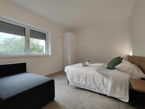 una camera bianca con un letto e una finestra di Oasi degli Ulivi a Riva del Garda