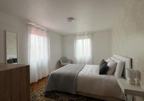 桑塔納的住宿－Vivenda Ferreira，白色卧室配有床和镜子