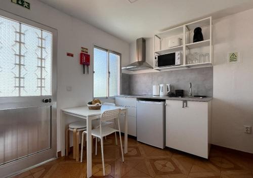 桑塔納的住宿－Vivenda Ferreira，厨房配有白色橱柜和桌椅