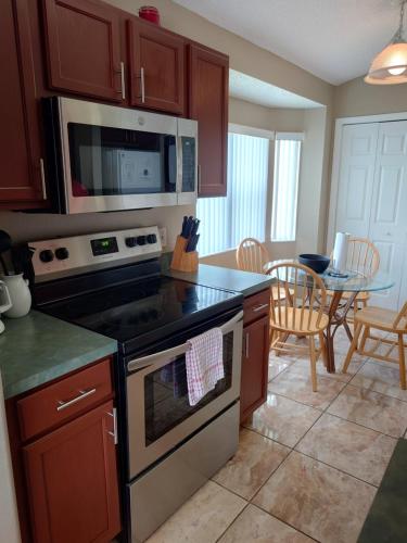 a kitchen with a stove and a microwave at Florida Villa in Kissimmee