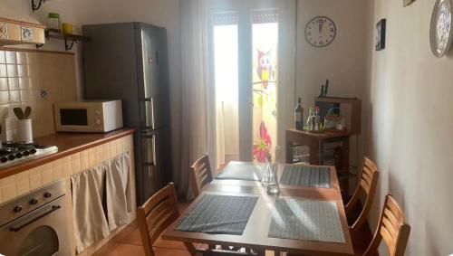 una cucina con tavolo, sedie e forno a microonde di Rosdani a Palermo