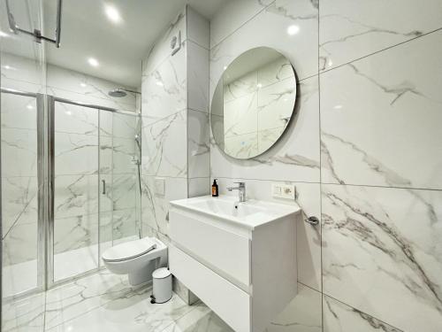 a bathroom with a sink and a toilet and a mirror at Maison du Roi in Liège