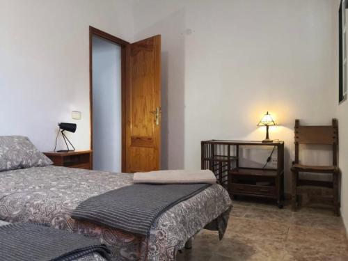 1 dormitorio con 1 cama y 1 mesa con lámpara en Fathill Finca, en Granadilla de Abona