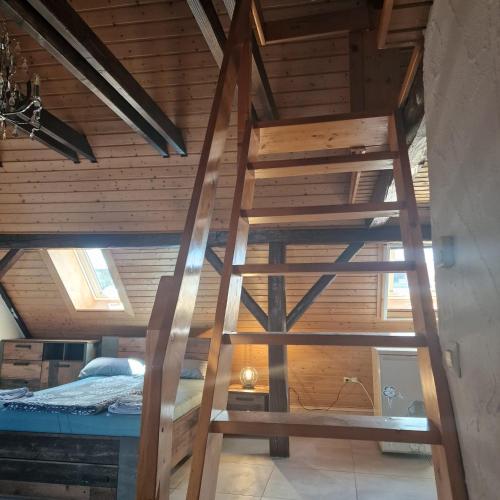 a wooden ladder in a room with a bed at Apartment da Luiz Salvatore in Wurmlingen